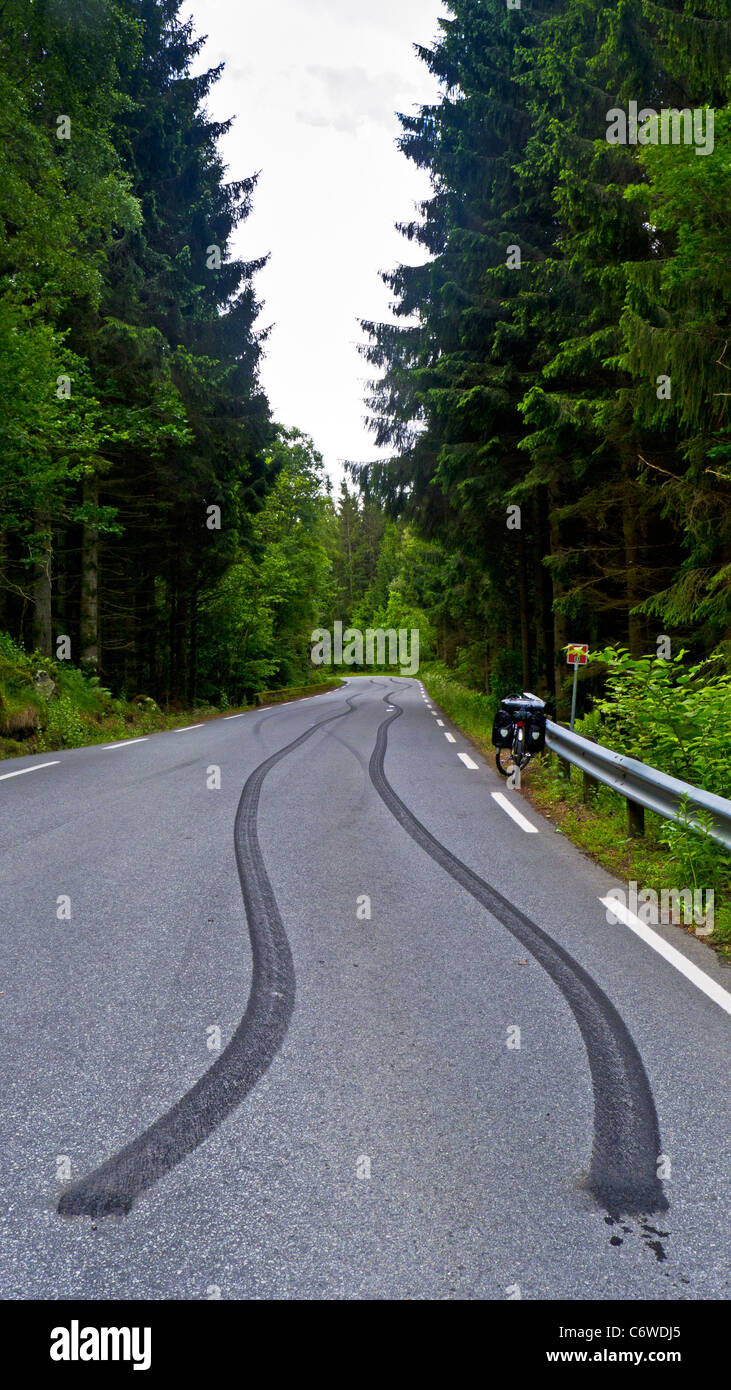Lungo nero slittamento dei pneumatici segni su un pubblico country road vicino Spangereid, Norvegia Foto Stock