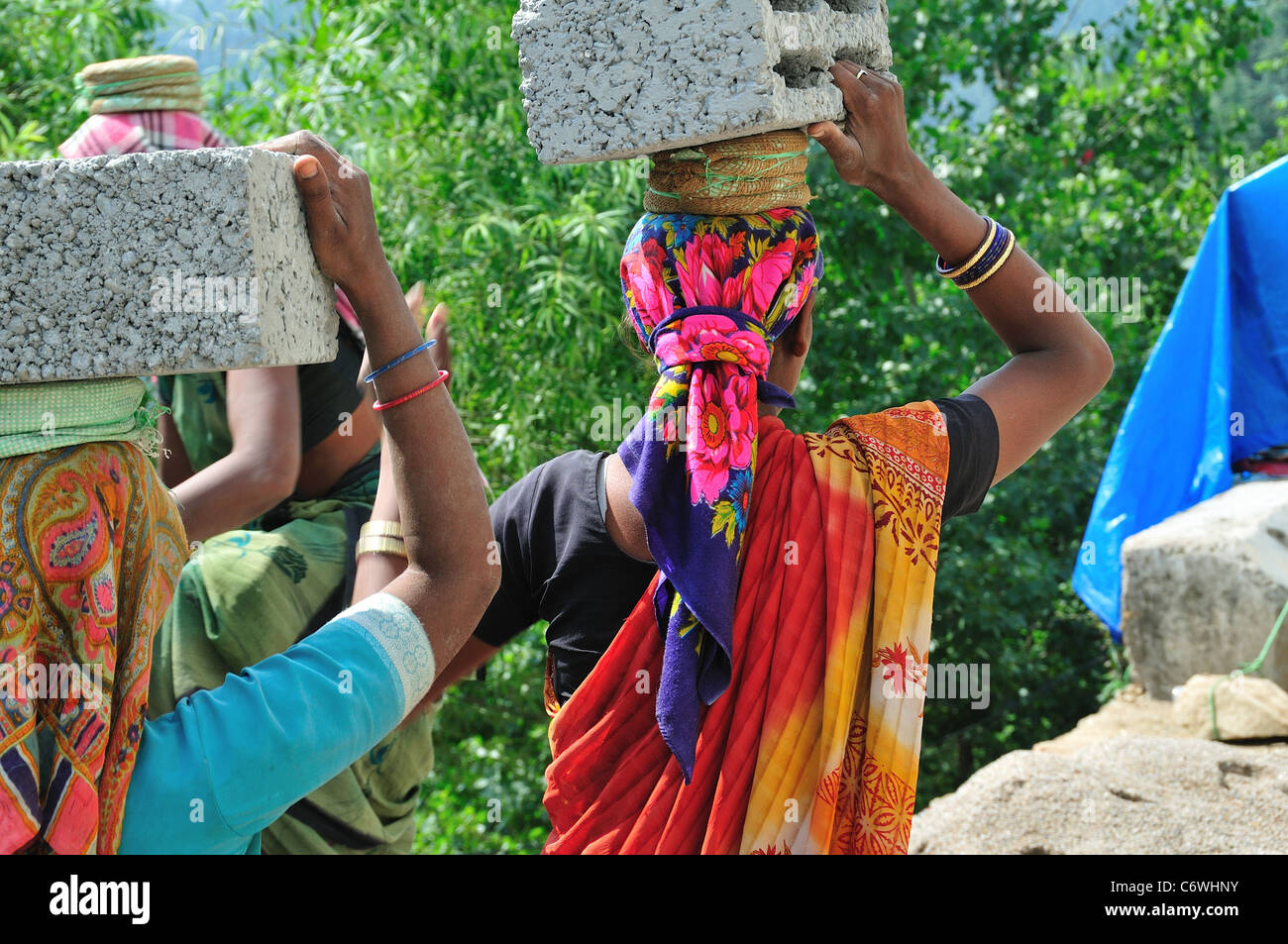 Indian lavoratori edili trasportare pesanti mattoni. Foto Stock