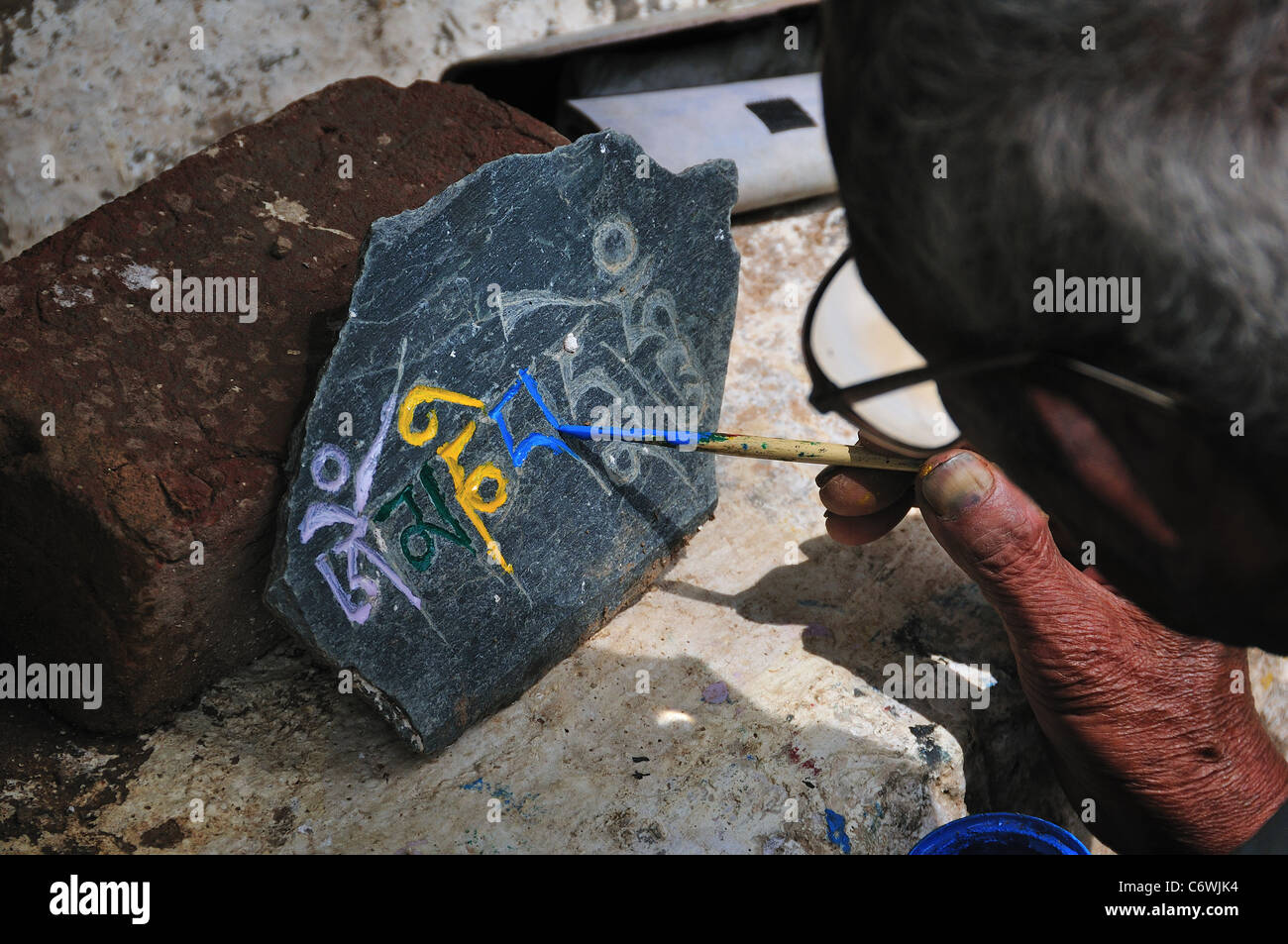 L'uomo pittura le mani la pietra. Foto Stock