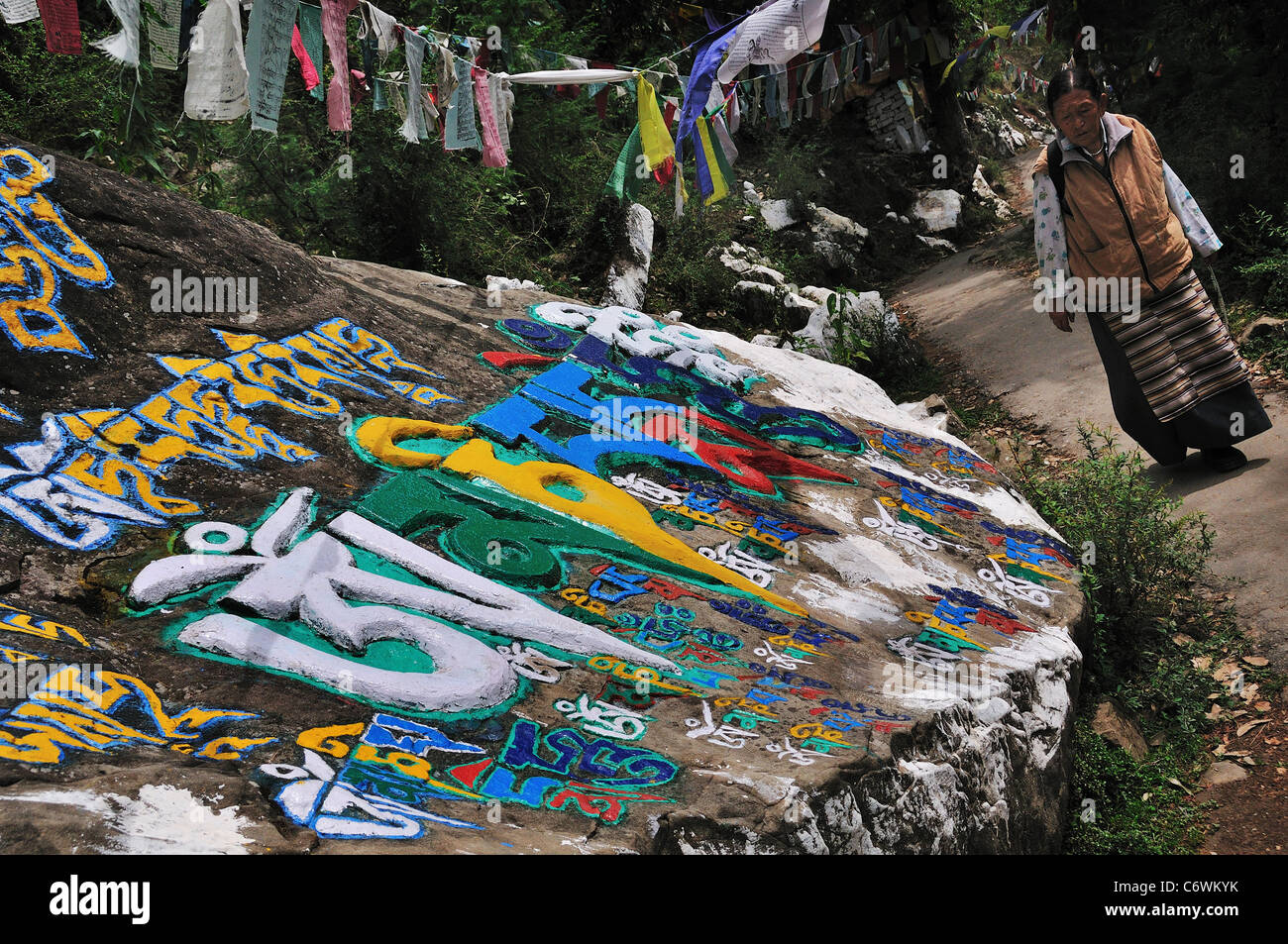 Donna tibetana passando attraverso mani la pietra. Foto Stock