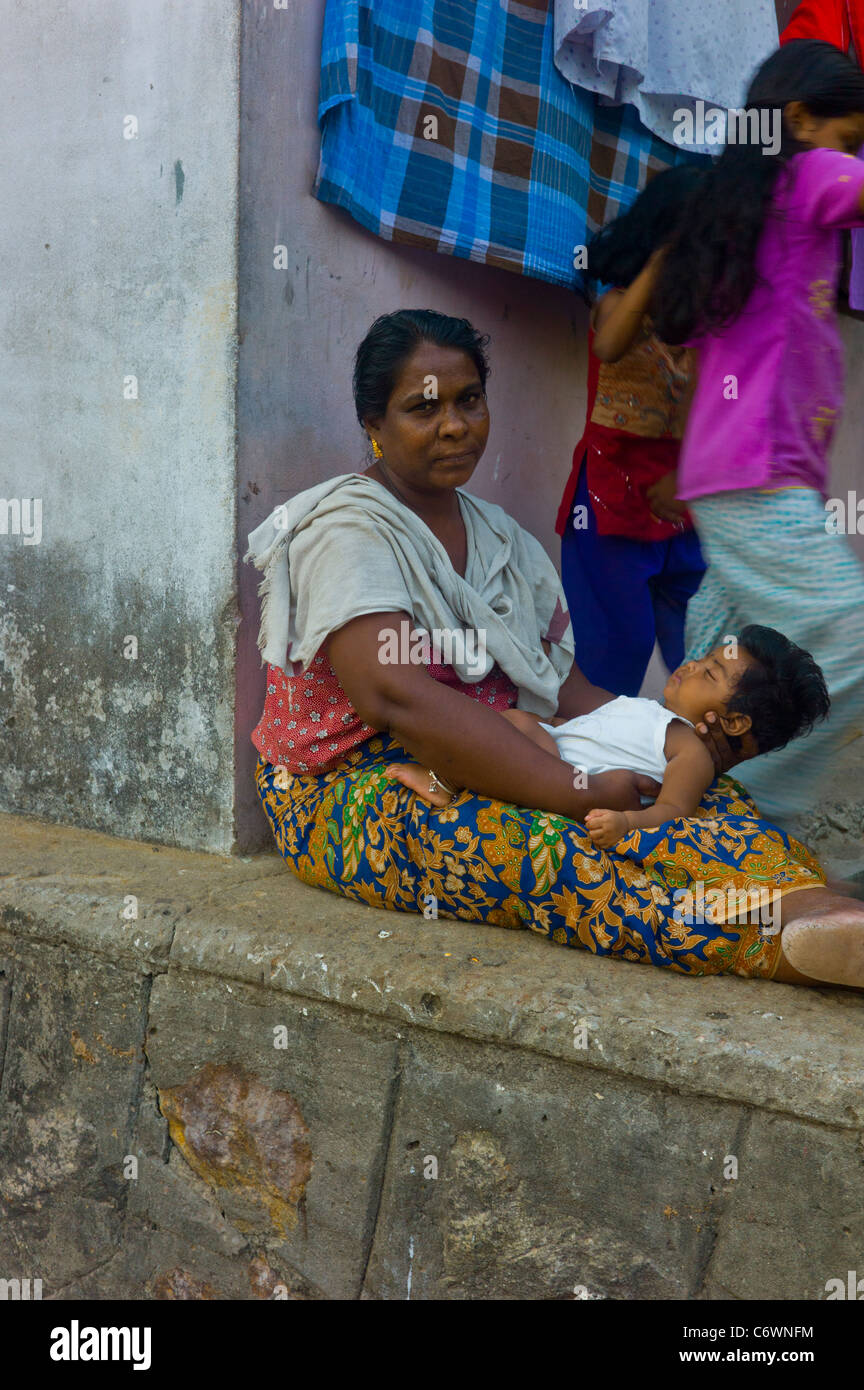 Famiglie indiano rilassarsi di fronte delle loro case in Quilon, Kerala. Foto Stock