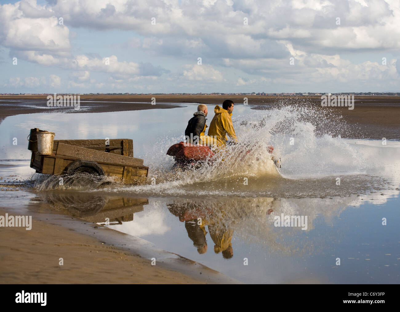 Cocktail in spiaggia con bassa marea su appartamenti di sabbia a Marshside all'inizio della stagione di Cockle picking. Incontro con le mani autorizzato a Southport, Merseyside, Regno Unito Foto Stock