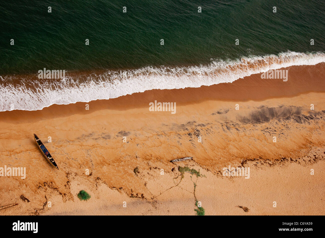 Un Birds Eye View di un solitario liberiano piroga di pesca su un telecomando tratto di costa atlantica. Foto Stock