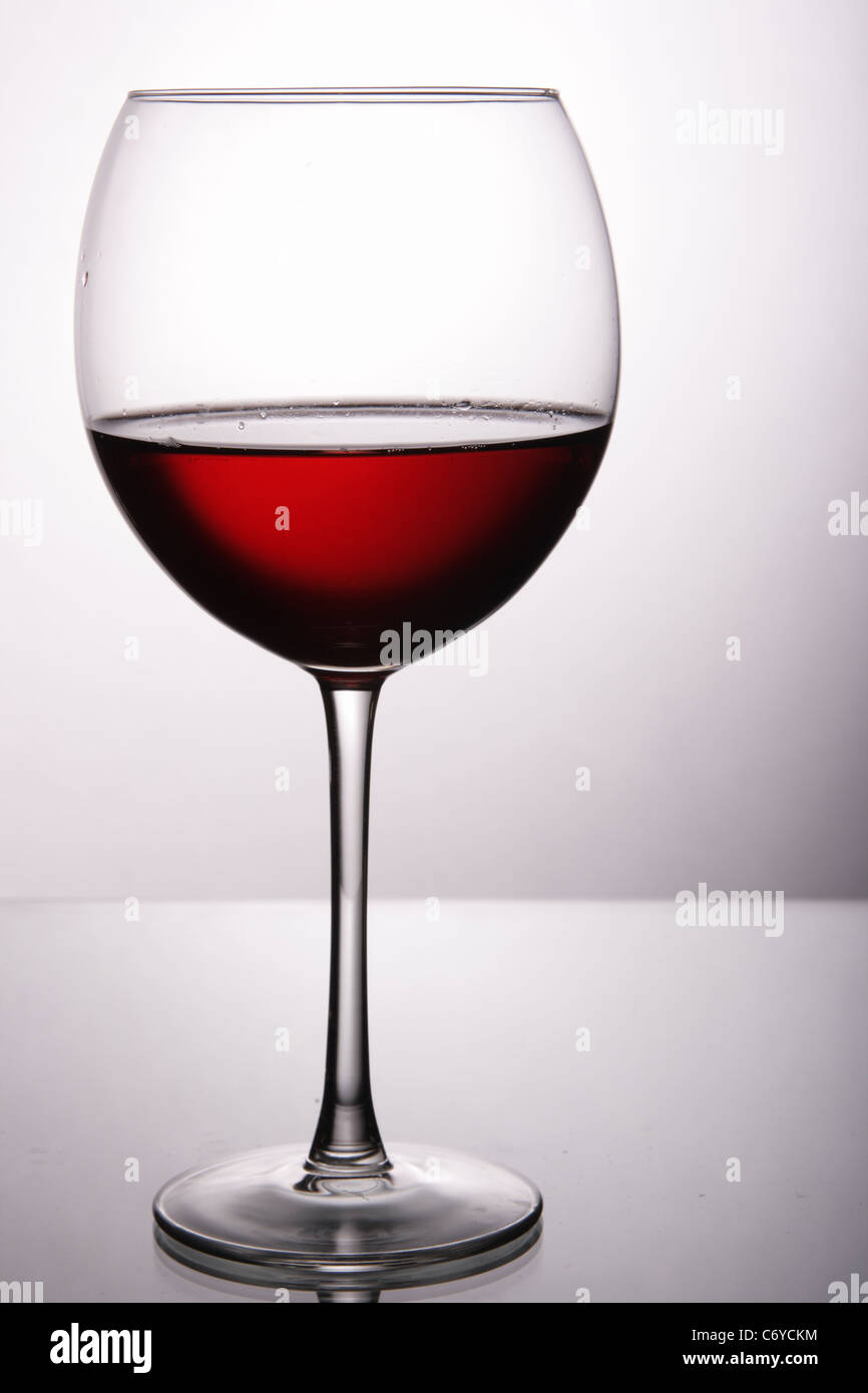 Bicchiere di vino rosso su grigio chiaro sfondo bianco Foto Stock