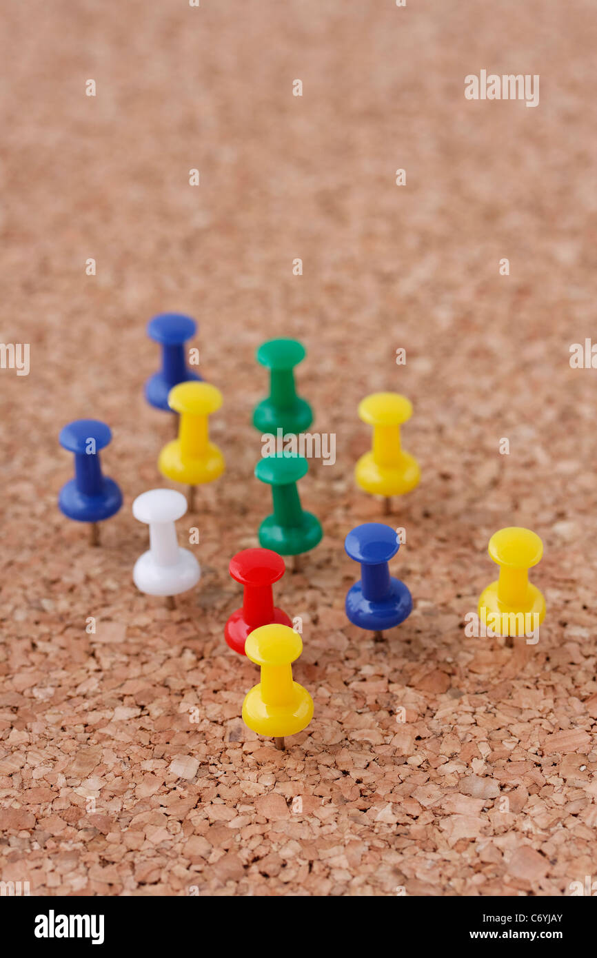 La disposizione delle puntine imperniata sulla bacheca di sughero Foto Stock