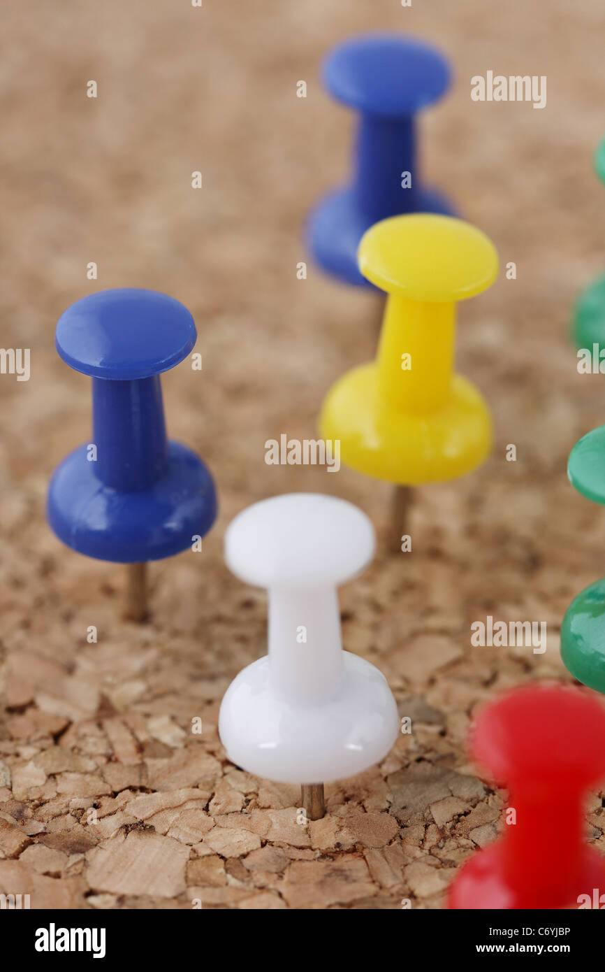 La disposizione delle puntine imperniata sulla bacheca di sughero Foto Stock