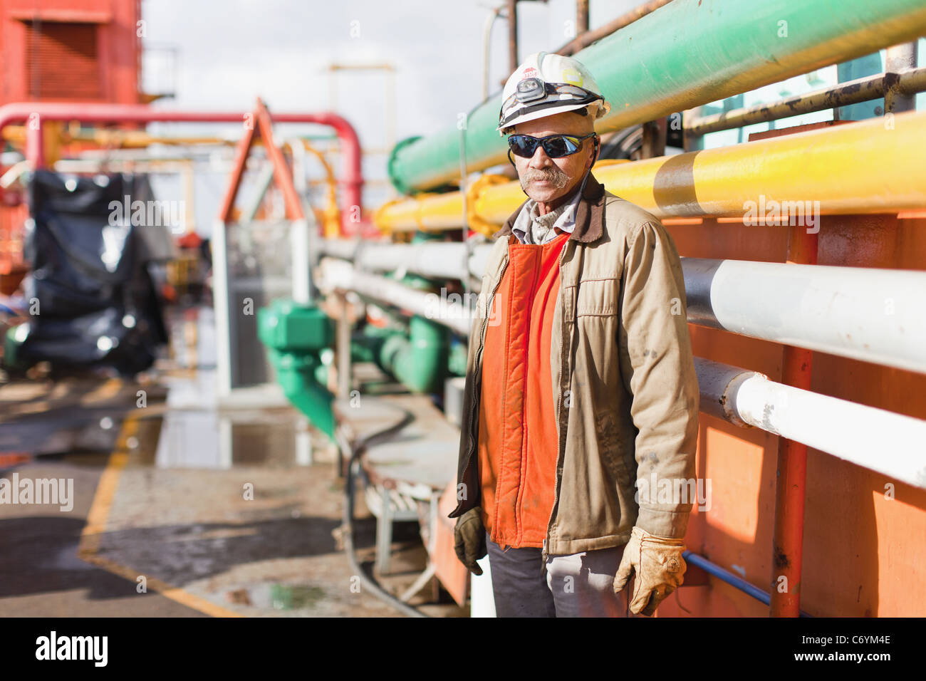 Lavoratore in piedi sulla piattaforma petrolifera Foto Stock