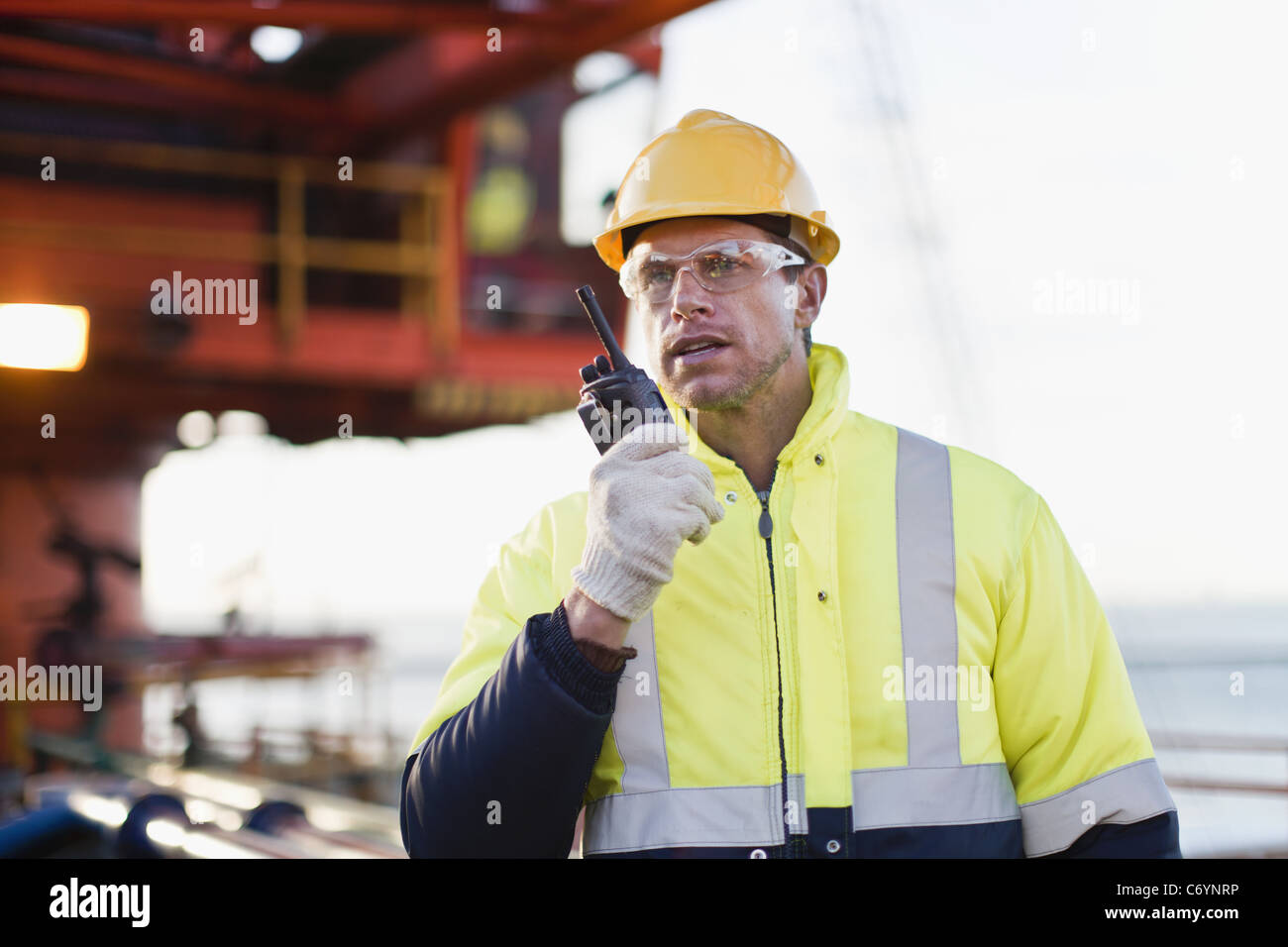 Lavoratore utilizzando walkie talkie sul oil rig Foto Stock