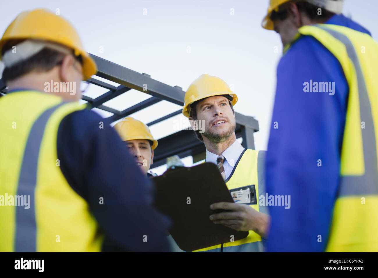 Lavoratori parlando al sito in costruzione Foto Stock
