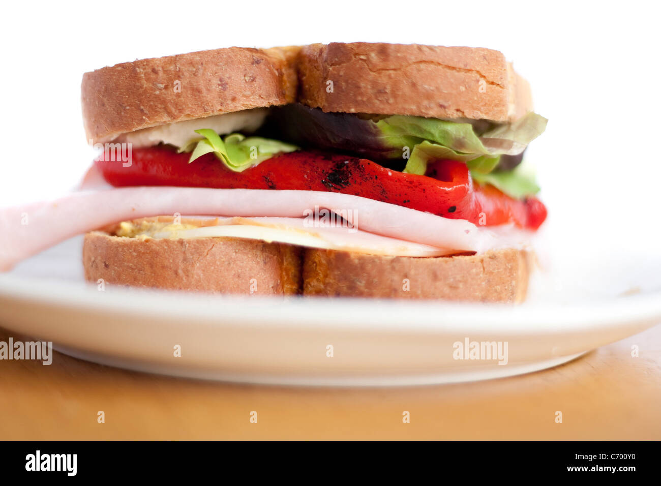 Un prosciutto e formaggio panino su una piastra isolata su bianco. Profondità di campo. Foto Stock