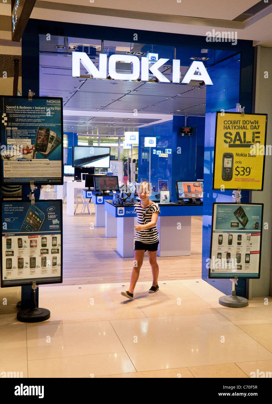 Una giovane ragazza proveniente da Nokia Store, lo ione Mall, Singapore Asia Foto Stock