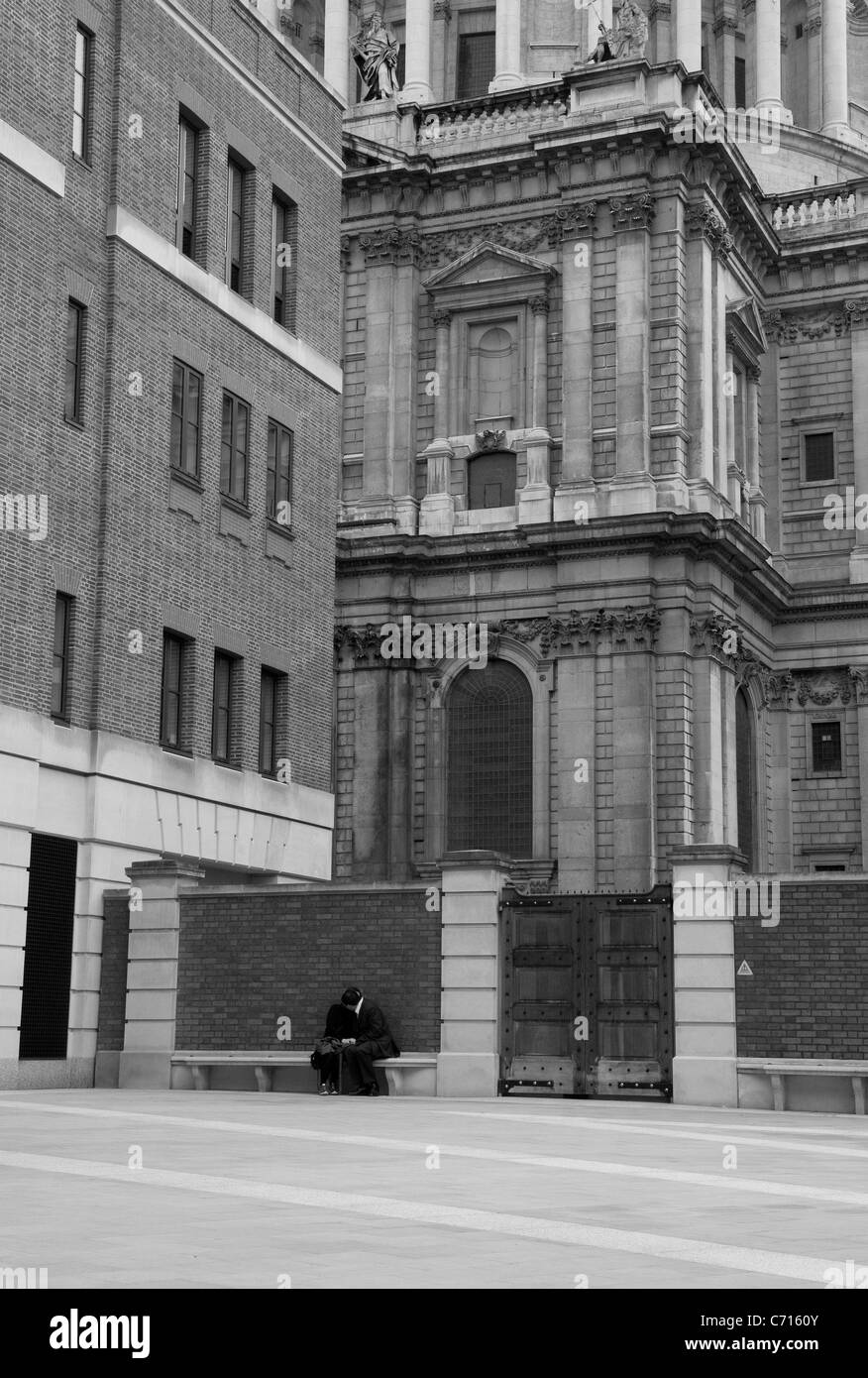 Un paio di baciare su un sedile dal famoso simbolo di Londra San Paolo Foto Stock