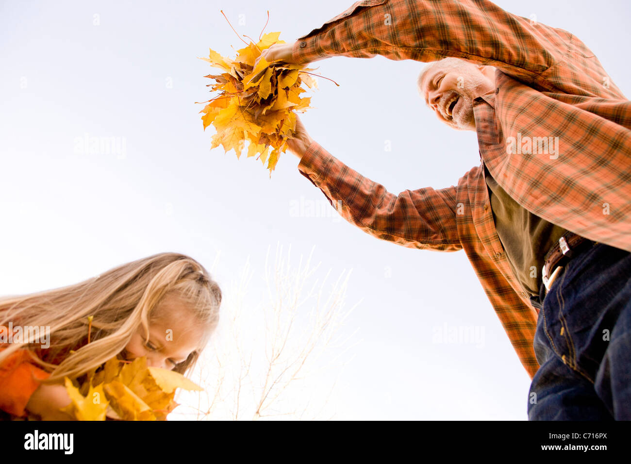 Nonno e nipote giocare con foglie di autunno Foto Stock