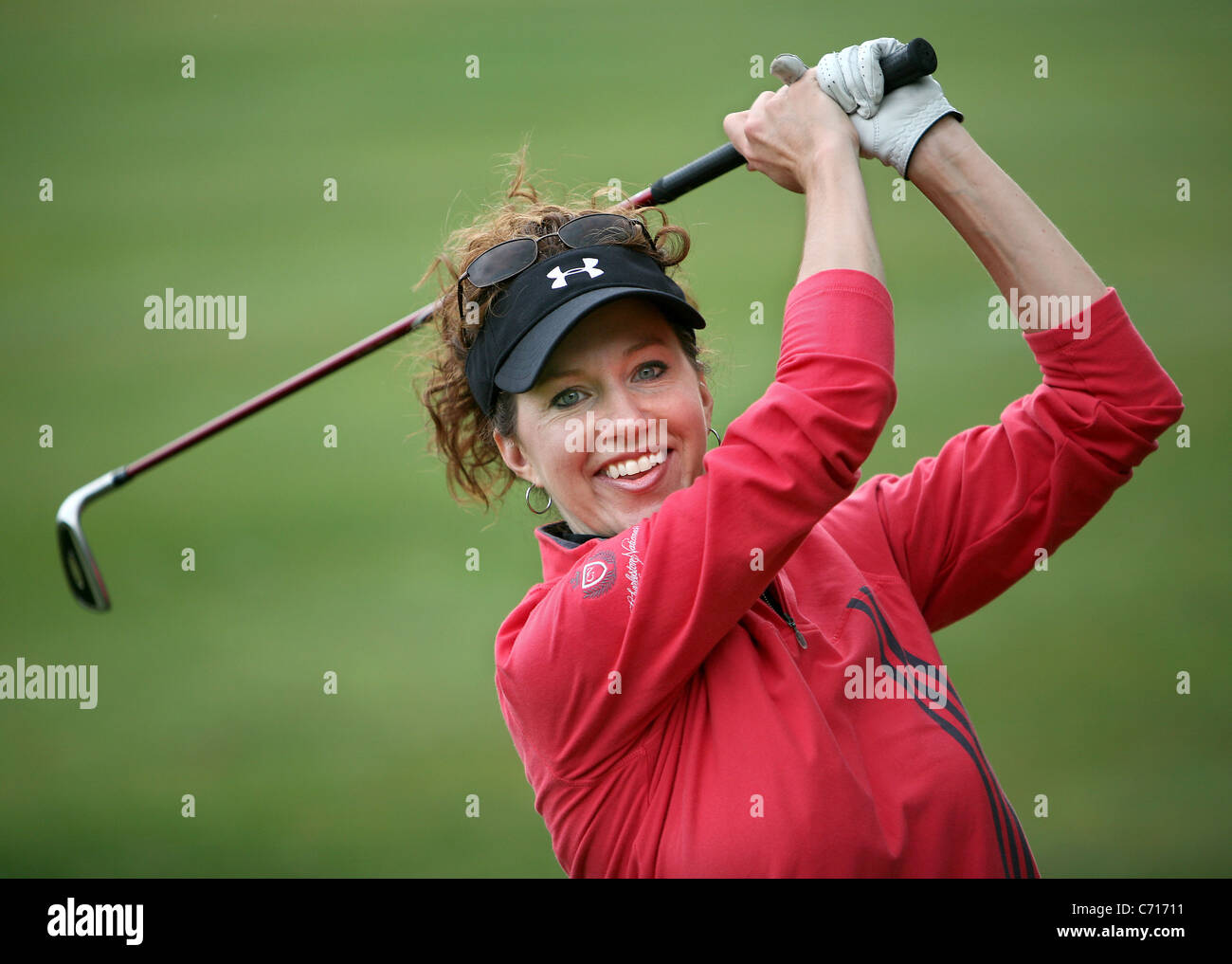 Un giocatore di golf femminile oscilla il suo club. Foto Stock