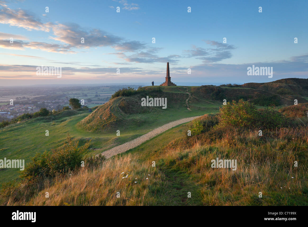 Giovane a guardare il tramonto dal Memoriale di guerra a Ham Hill Country Park. Somerset. In Inghilterra. Regno Unito. Foto Stock