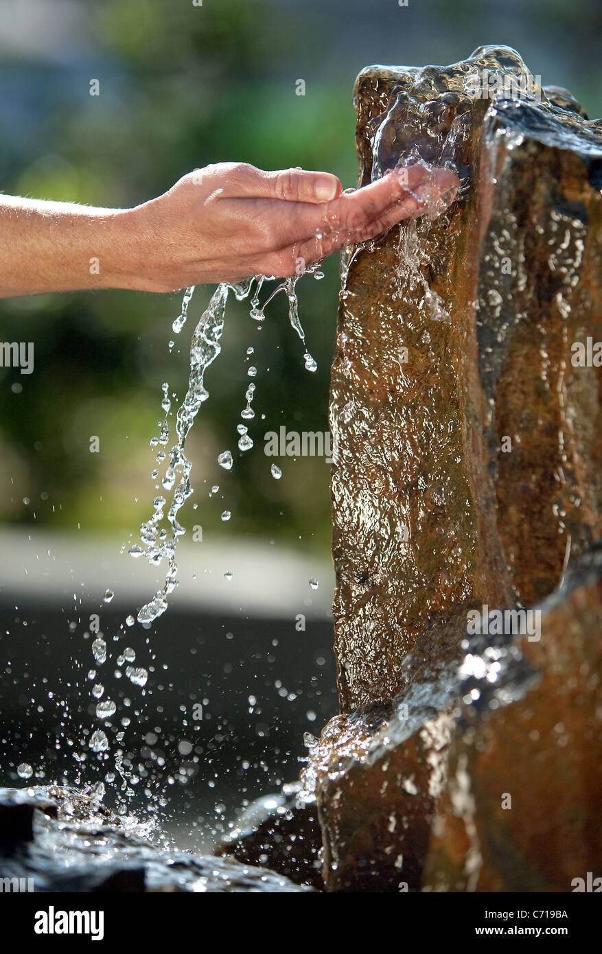 Acqua si riversa su un lato da una roccia fontana. Foto Stock