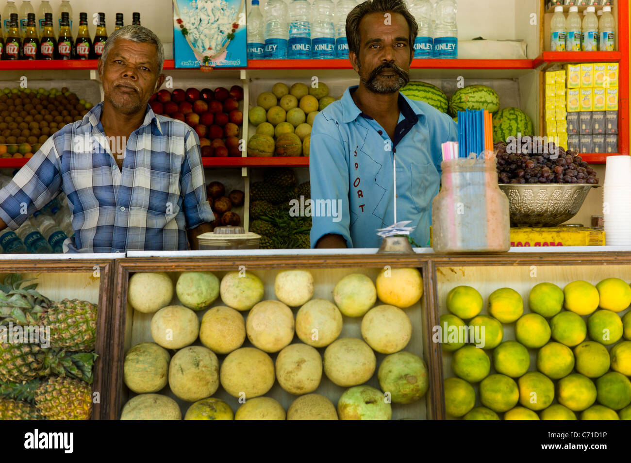 I dipendenti di un succo di frutta fresca in stallo per le strade di Madurai, Tamil Nadu, India. Foto Stock