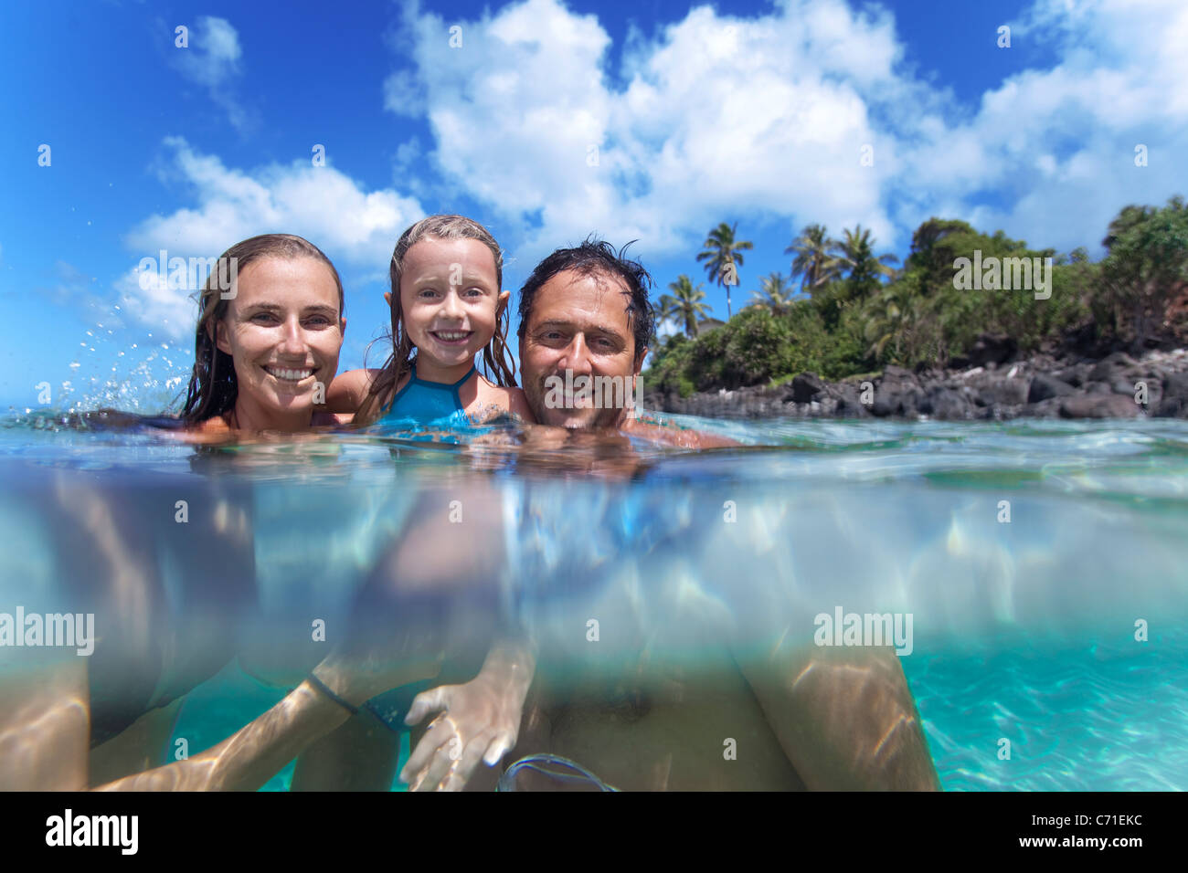 Un livello diviso vista di una giovane famiglia in acqua a Waimea Bay. Foto Stock