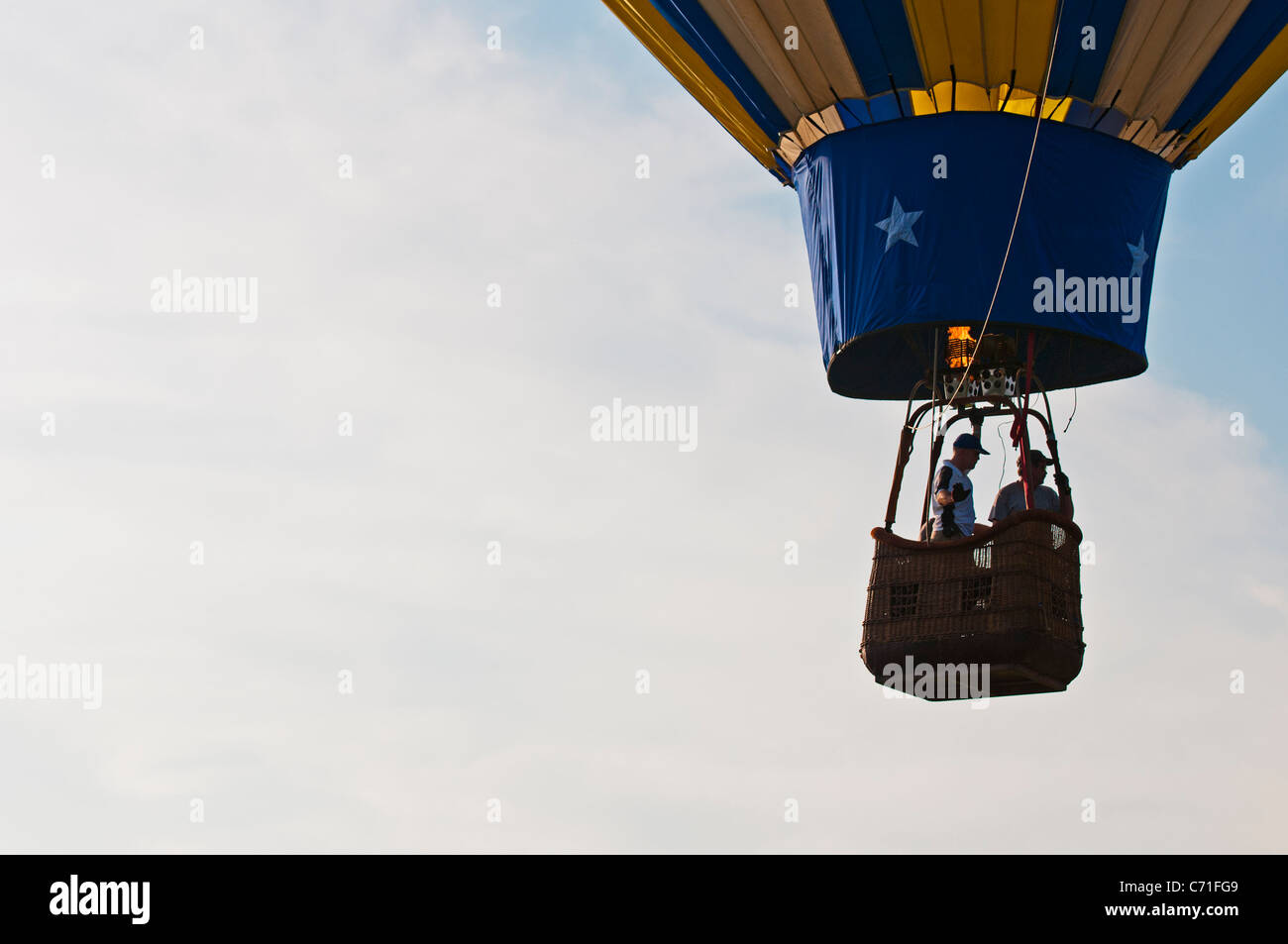 Mongolfiera rising profilarsi davanti a un nuvoloso cielo blu Foto Stock