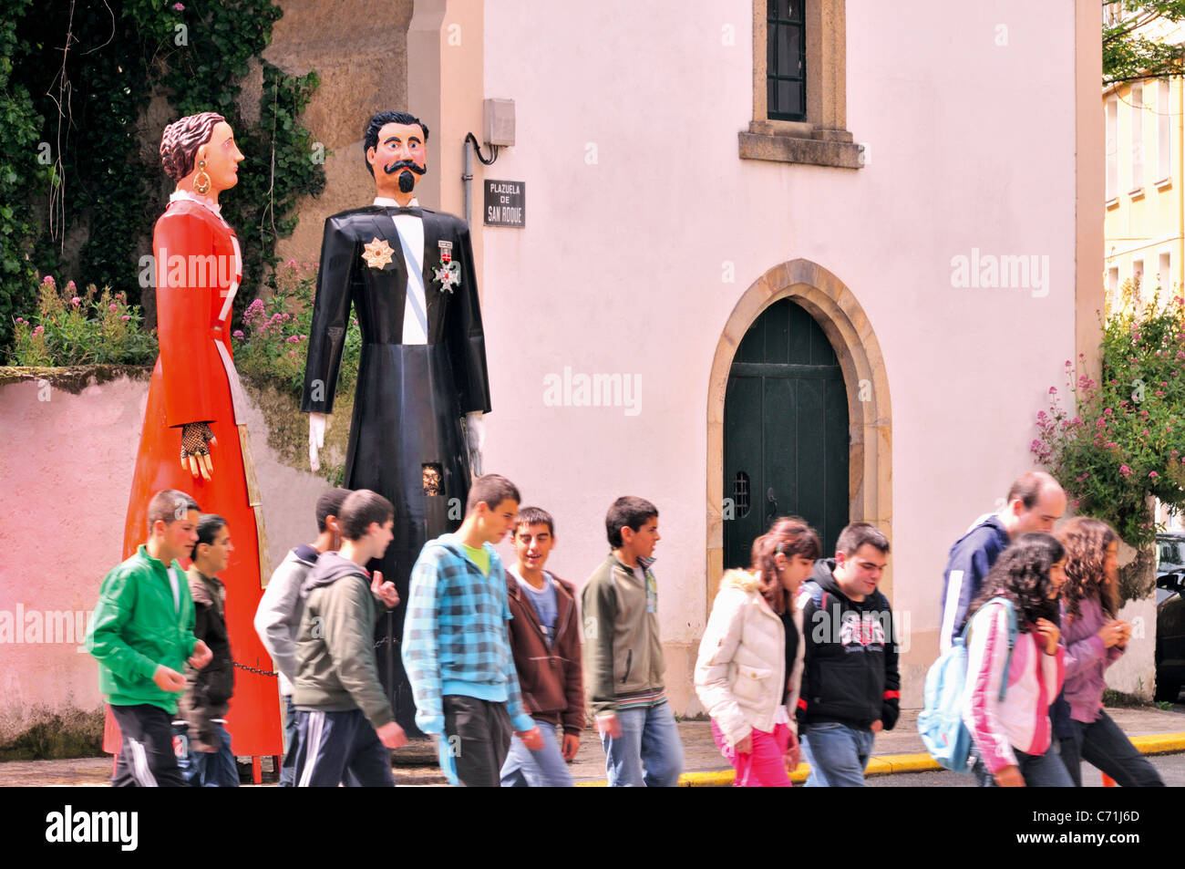 Spagna Galizia: Scuola classe passando il gigante bambole 'Os Cocos' nel centro di Ribadeo Foto Stock