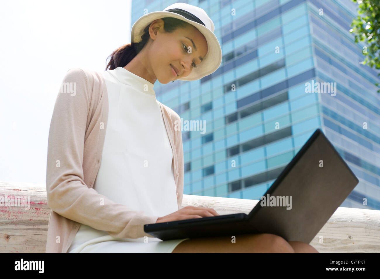 Donna che utilizza computer portatile all'aperto, a basso angolo di visione Foto Stock