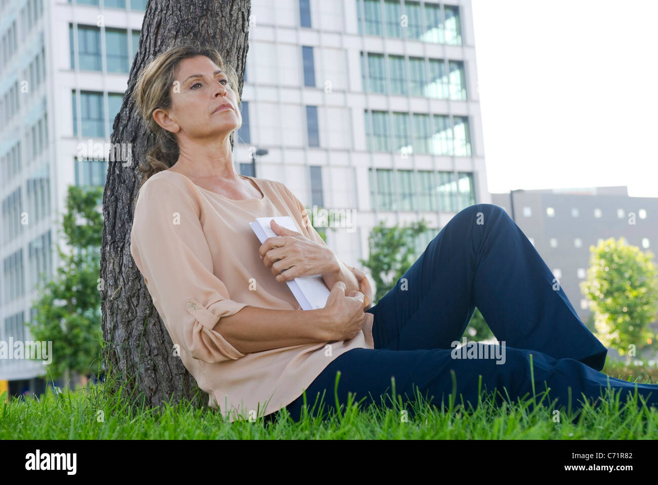 Donna seduta in erba, libro di innesto Foto Stock