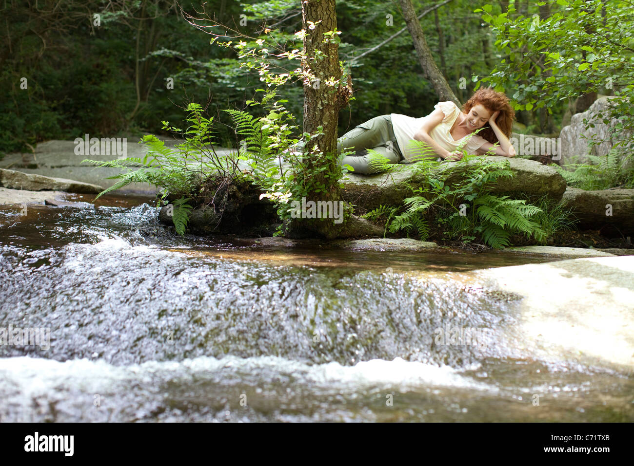 Giovane donna relax su rock di flusso Foto Stock