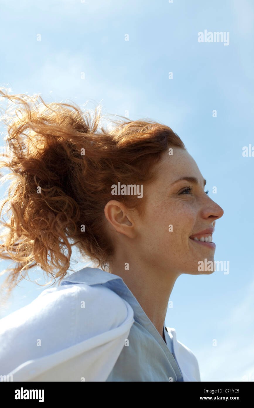 Donna sorridente all'aperto, profilo Foto Stock