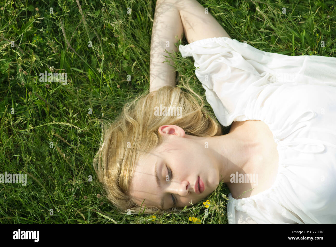 Giovane donna napping sull'erba Foto Stock