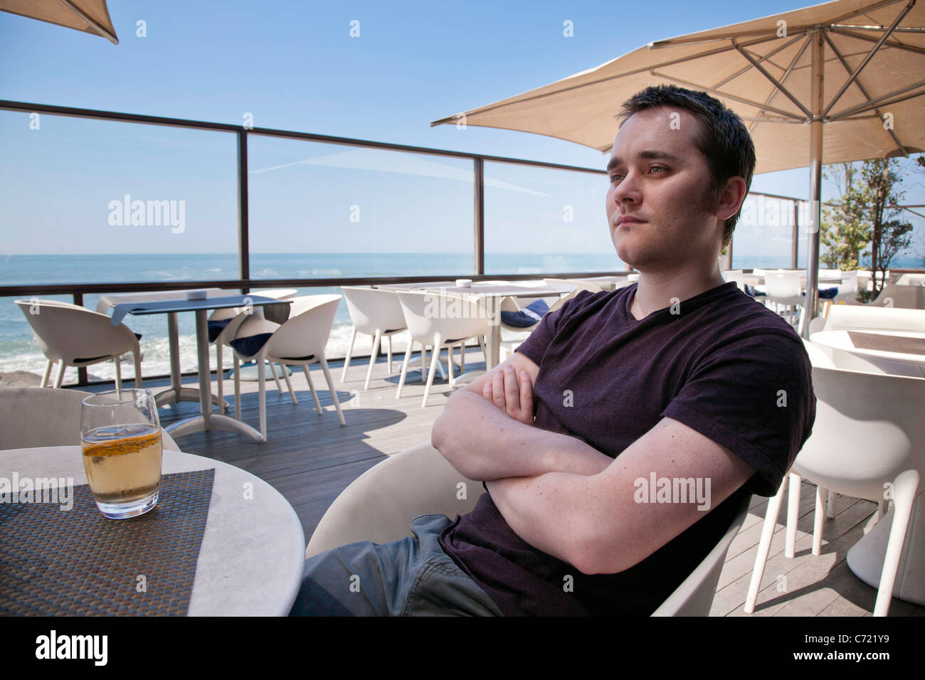 Giovane uomo seduto in un bar a Foz do Douro Foto Stock