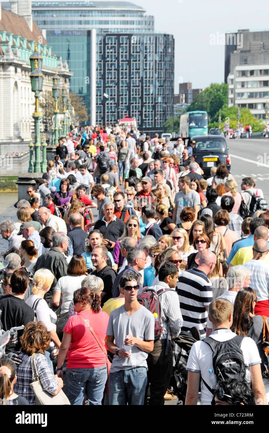 Folla di turisti che camminano su strade trafficate al Westminster Bridge che si spostano da e per le popolari attrazioni turistiche della South Bank Londra Inghilterra UK Foto Stock