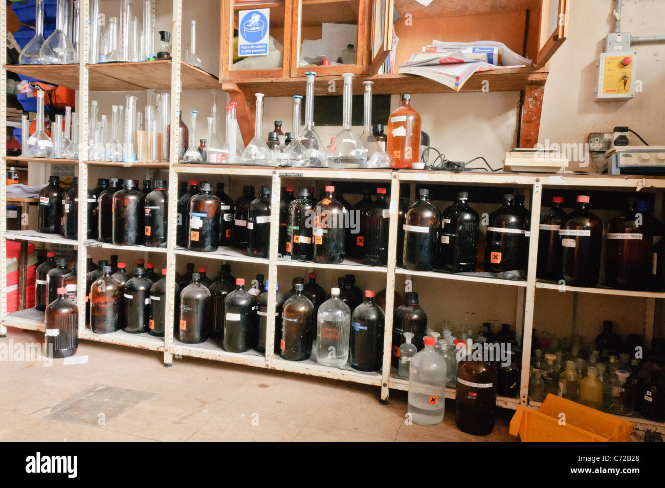 Sostanze chimiche sugli scaffali di una scuola laboratorio di chimica Foto Stock