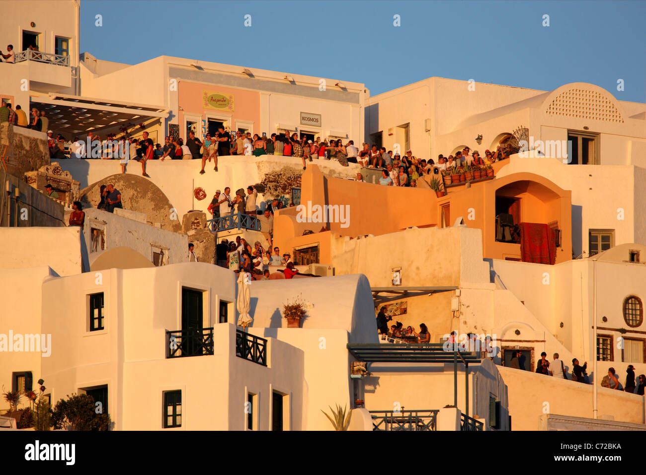 Centinaia di 'sunset dei cacciatori sono raccolti ogni sera a terrazze e vicoli di Oia per godere il suo famoso tramonto. Santorini Foto Stock