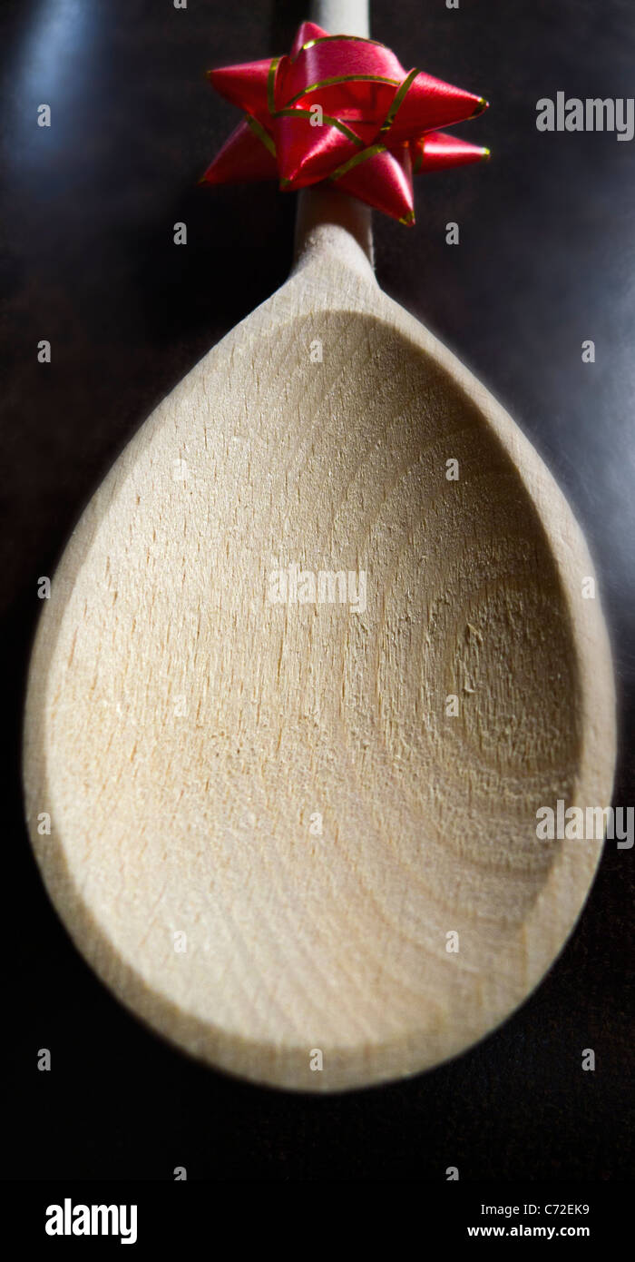 Un cucchiaio di legno con una coccarda attaccato allo stelo della maniglia. Foto Stock