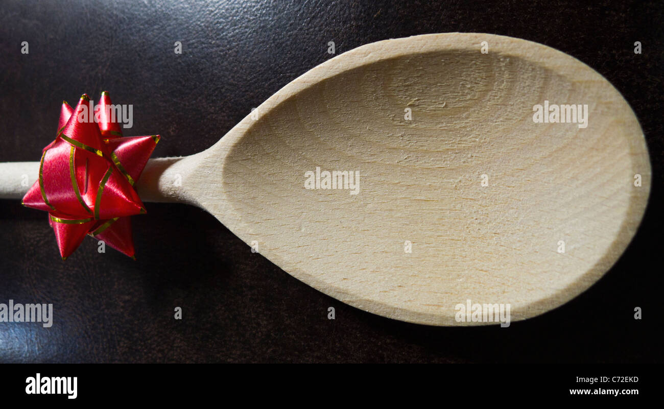 Un cucchiaio di legno con una coccarda attaccato allo stelo della maniglia. Foto Stock