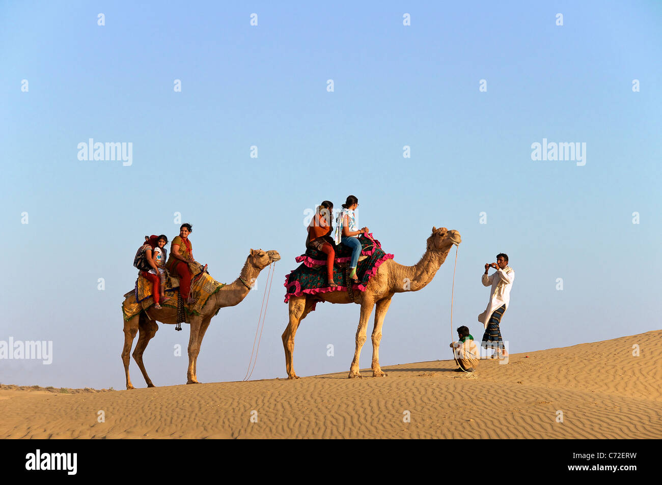 Indian i turisti sui cammelli avente le foto scattate a Sam le dune del deserto Parco Nazionale Western Rajasthan in India Foto Stock