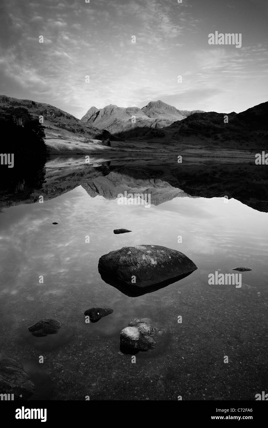 Ritratto in bianco e nero di formato di immagine The Langdale Pikes riflessa nella calma Blea Tarn nel Lake District inglese Foto Stock