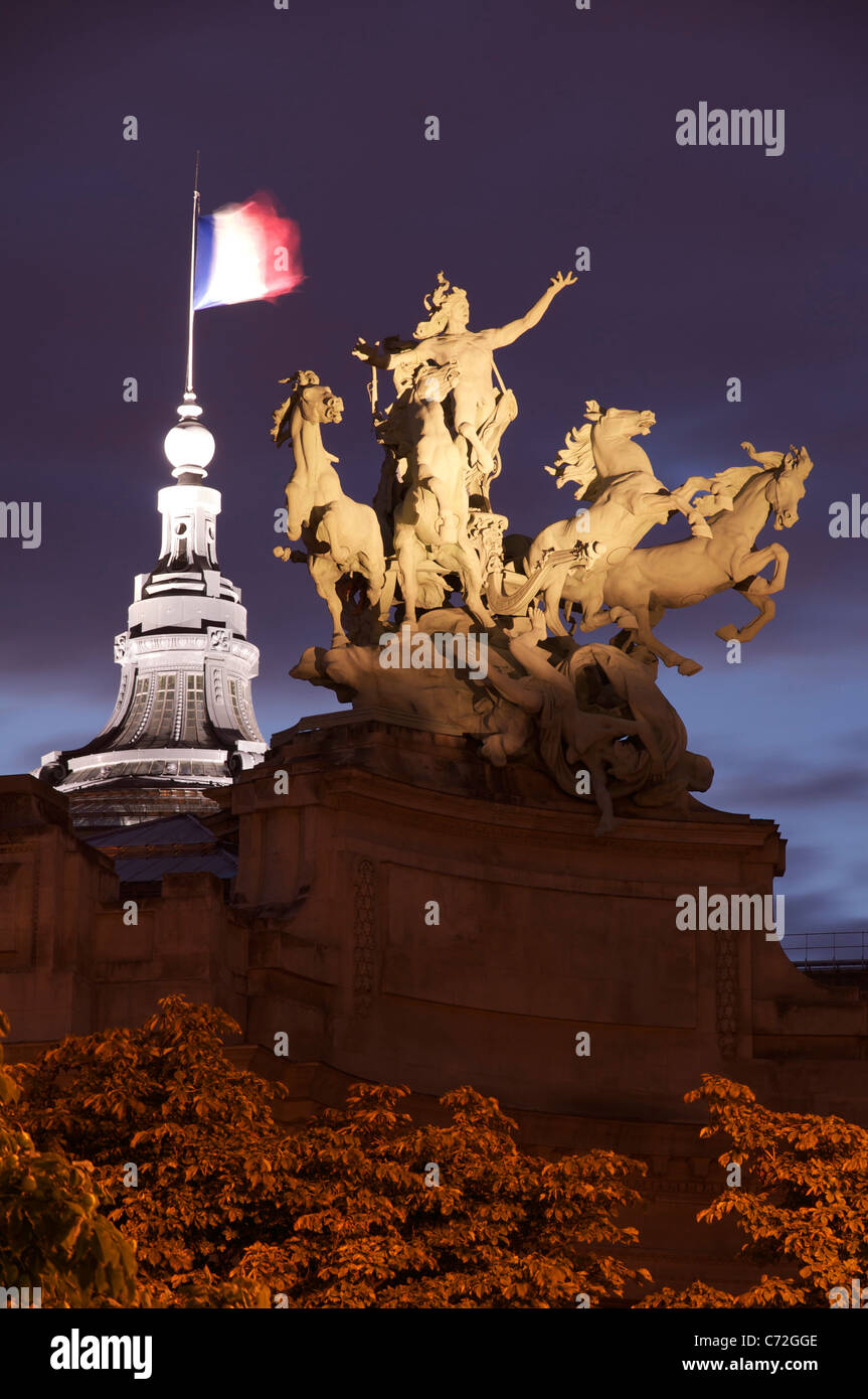 Un enorme illuminata scultura in bronzo di Georges Récipon di una quadriga, un carro trainato da quattro cavalli, in cima all'Art Nouveau Grand Palais di Parigi. La Francia. Foto Stock