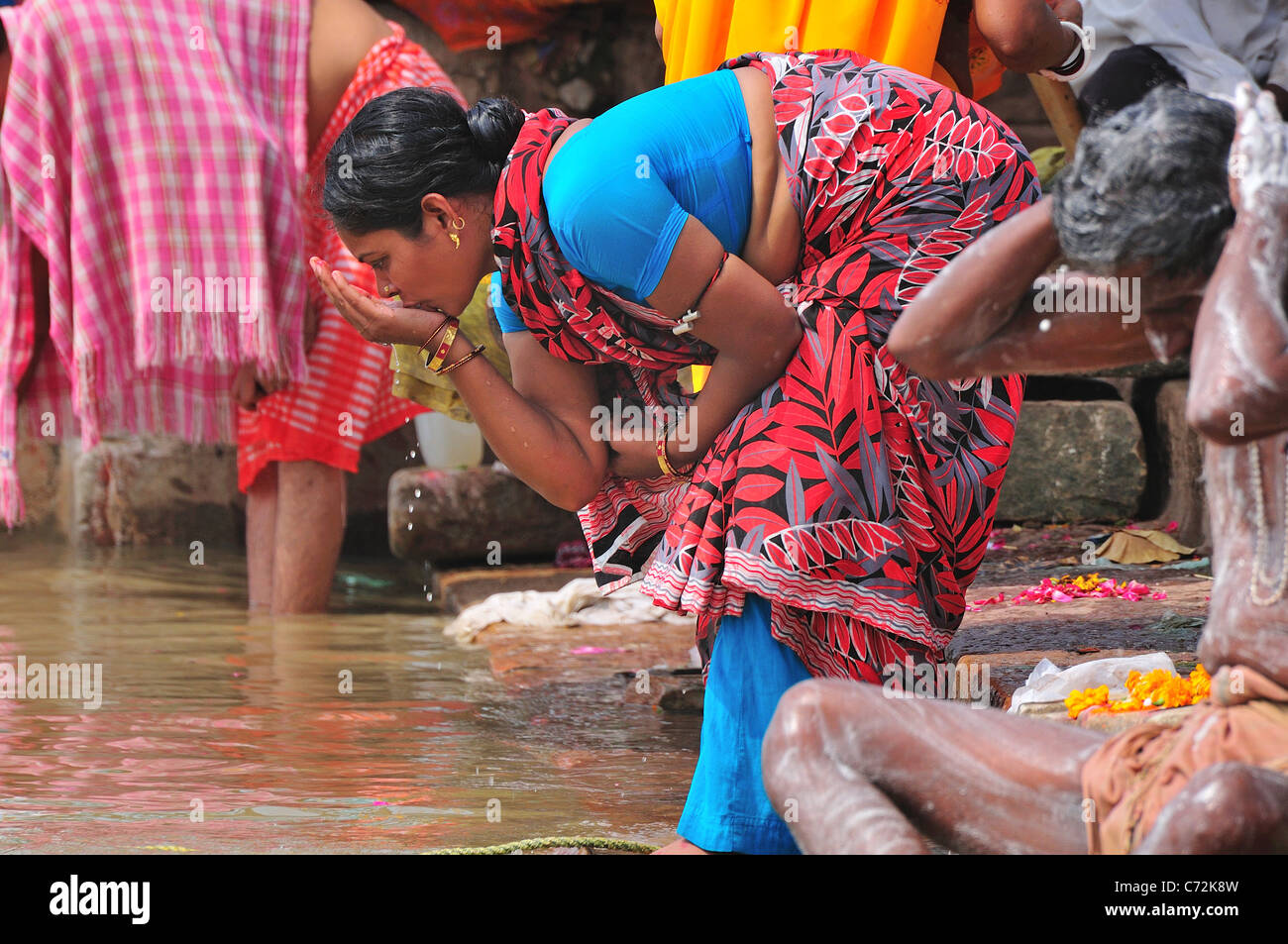 Pellegrino donna orante a ghat dal fiume Gange. Foto Stock