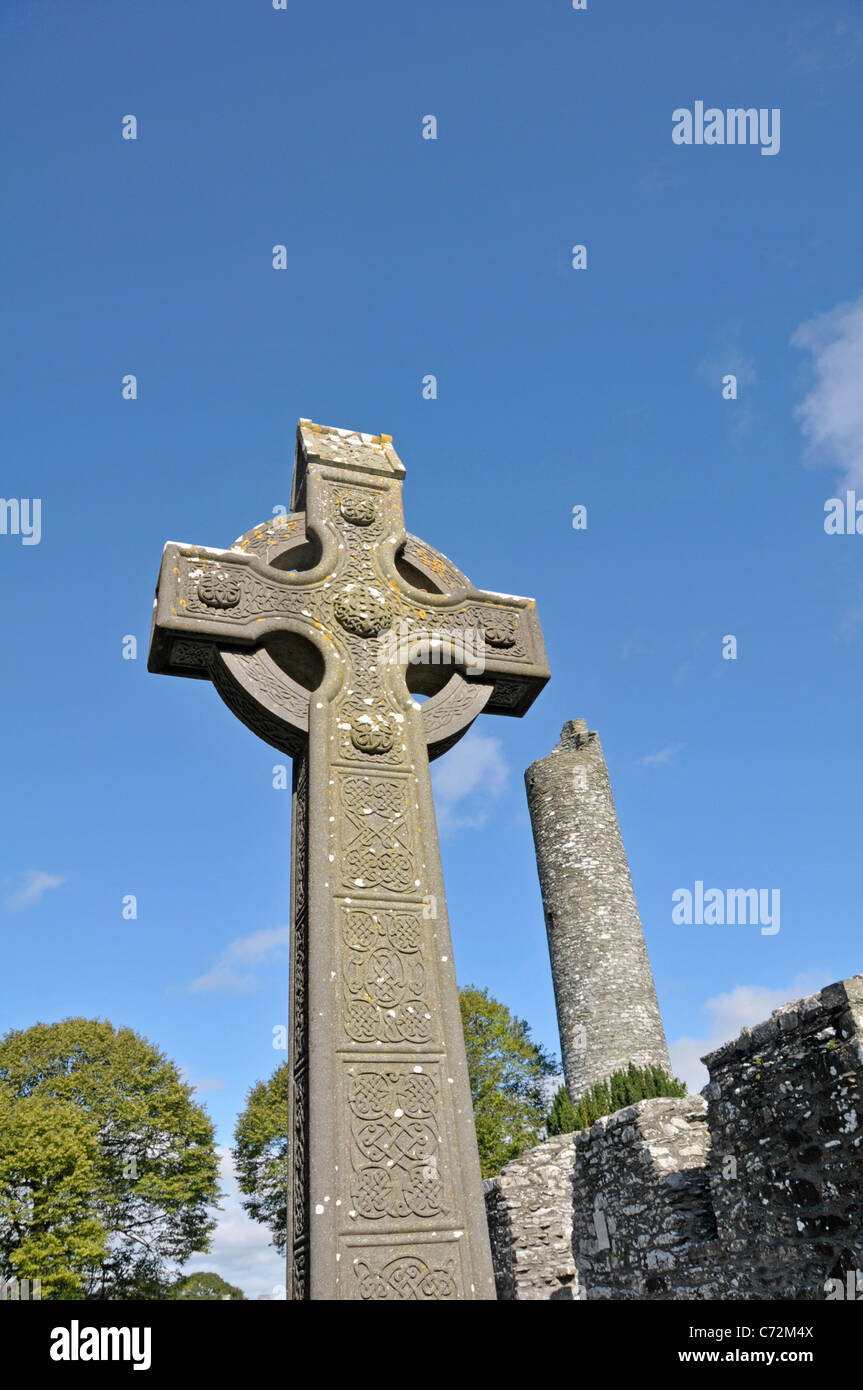 Monasterboice, nella contea di Louth, Irlanda. Croce celtica e resti della torre rotonda Foto Stock