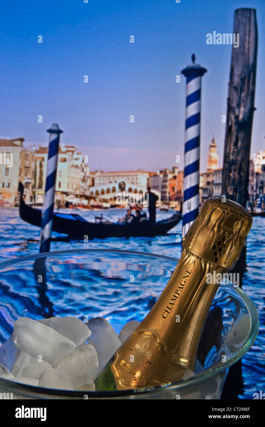 Concetto / bottiglia di champagne su ghiaccio con gondola veneziana e il Ponte di Rialto dietro. Venezia Italia Foto Stock