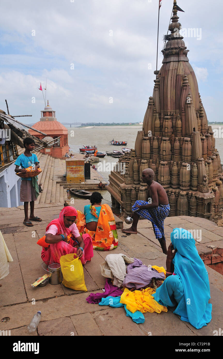 Pellegrini rilassante dopo la balneazione a ghat dal fiume Gange. Foto Stock