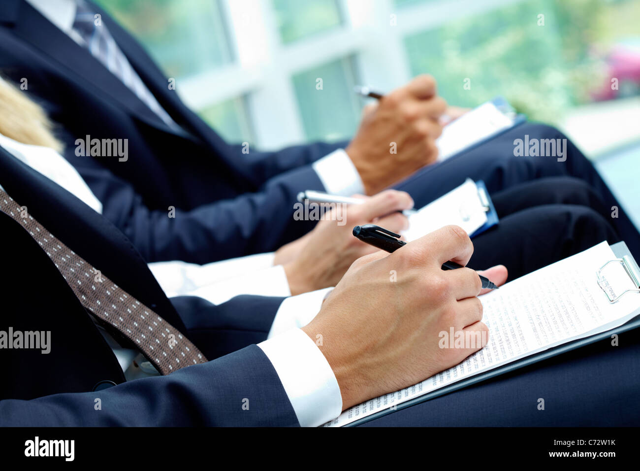Close-up di gente di affari le mani con carte a scrivere a lezione Foto Stock