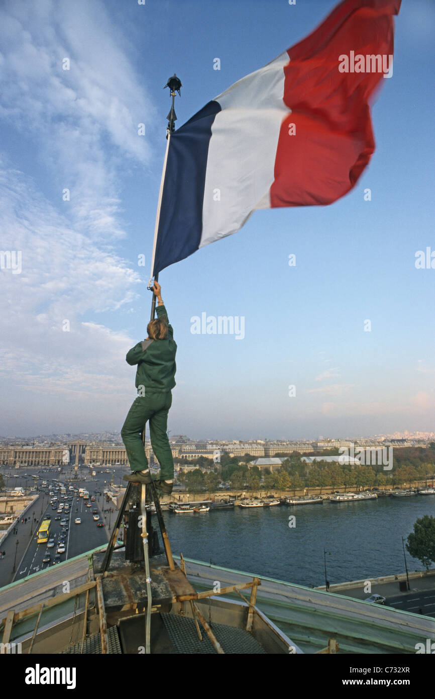 Tricolore francese bandiera francese di essere issato sul tetto dell'Assemblea nazionale vista sulla Senna e Place de la Concorde P Foto Stock