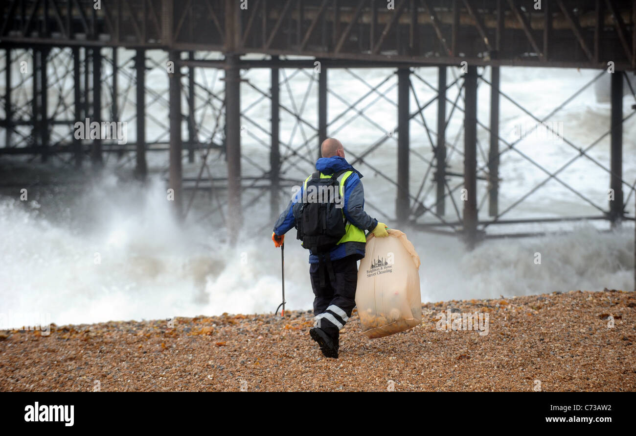 A Brighton e Hove city council lavoratore riordino ancora la spiaggia di lettiera oggi nonostante il forte vento e pioggia REGNO UNITO Foto Stock