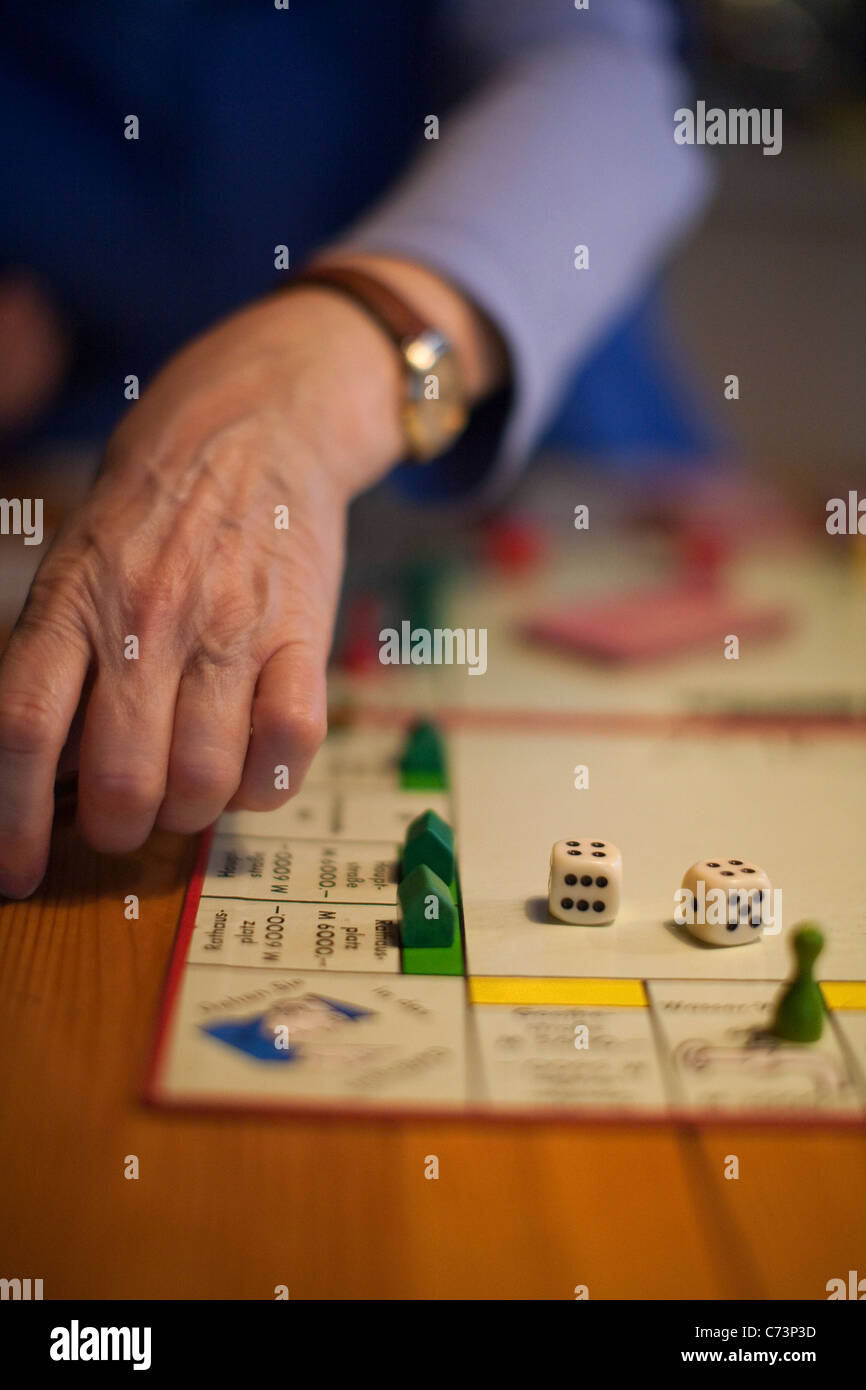 Gioco di monopoli e la mano del giocatore, dettaglio, intrattenimento per tutta la famiglia, Germania Foto Stock