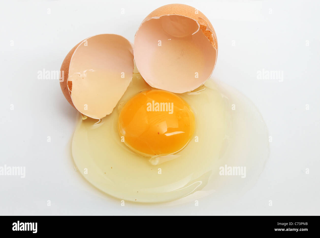 Uova incrinate e shell su sfondo bianco Foto Stock