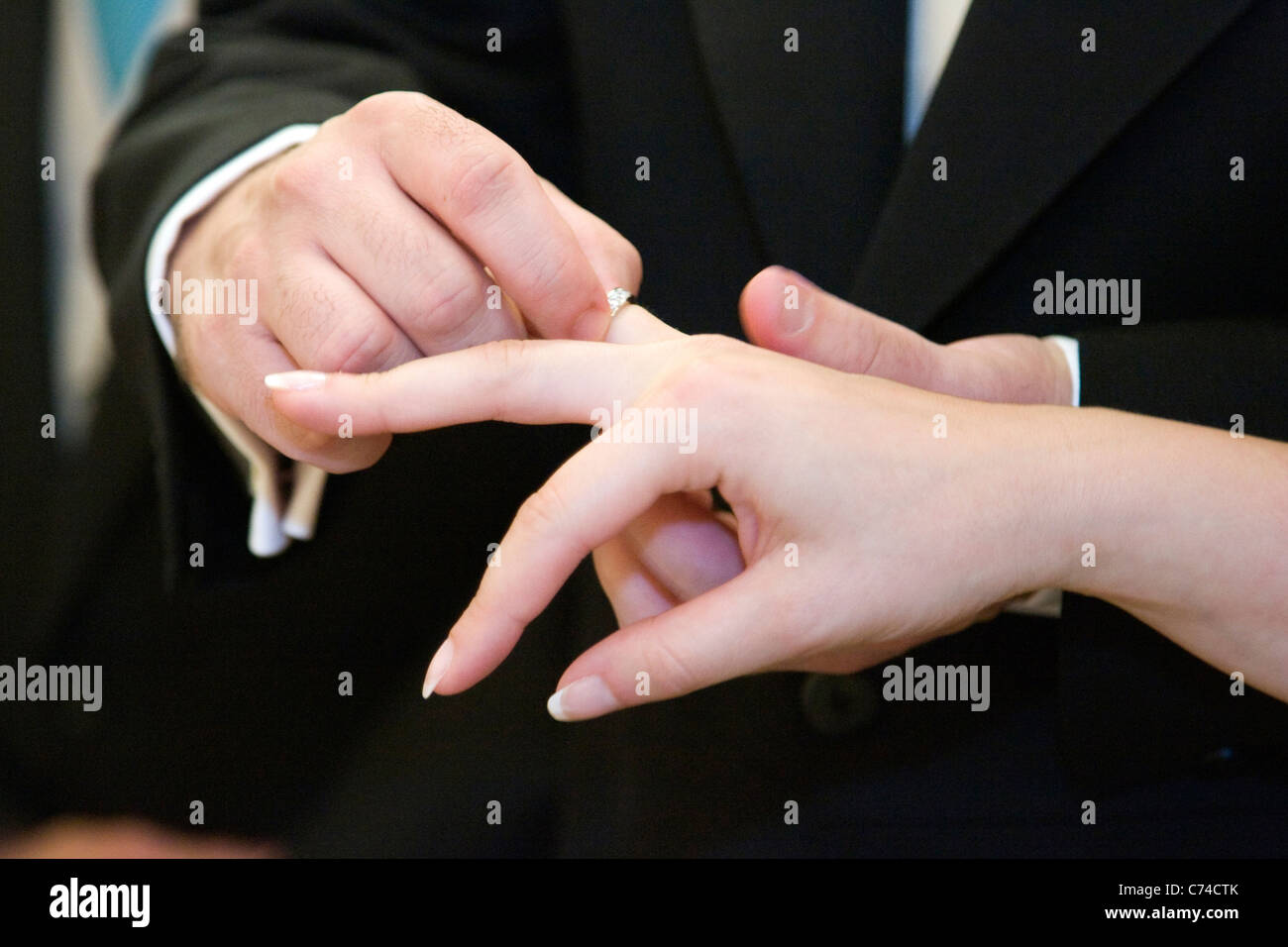 Un groom mettere un anello al dito della sposa Foto Stock