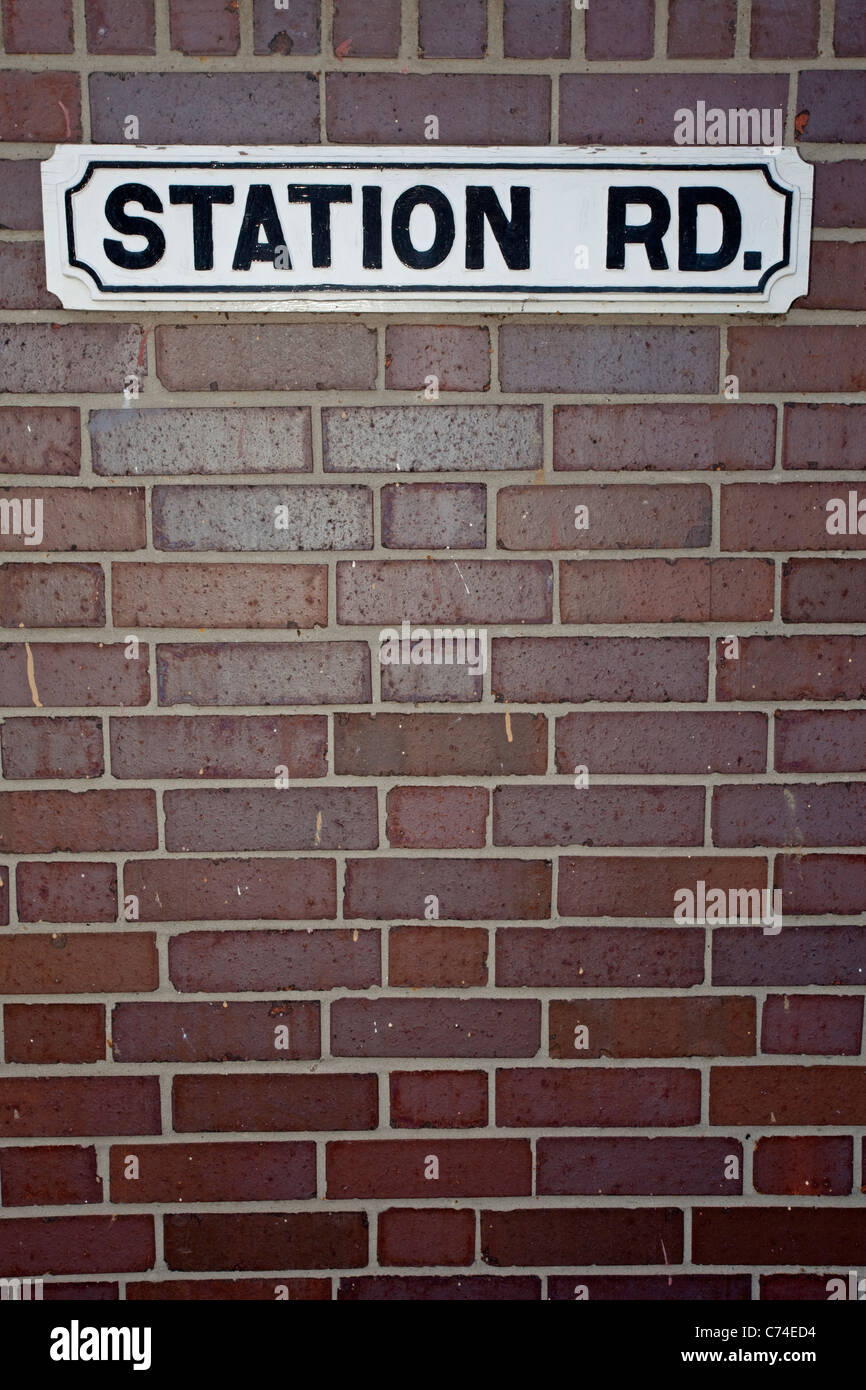 Station Road Sign sulla sommità di un muro di mattoni con lo spazio qui sotto per il testo Foto Stock