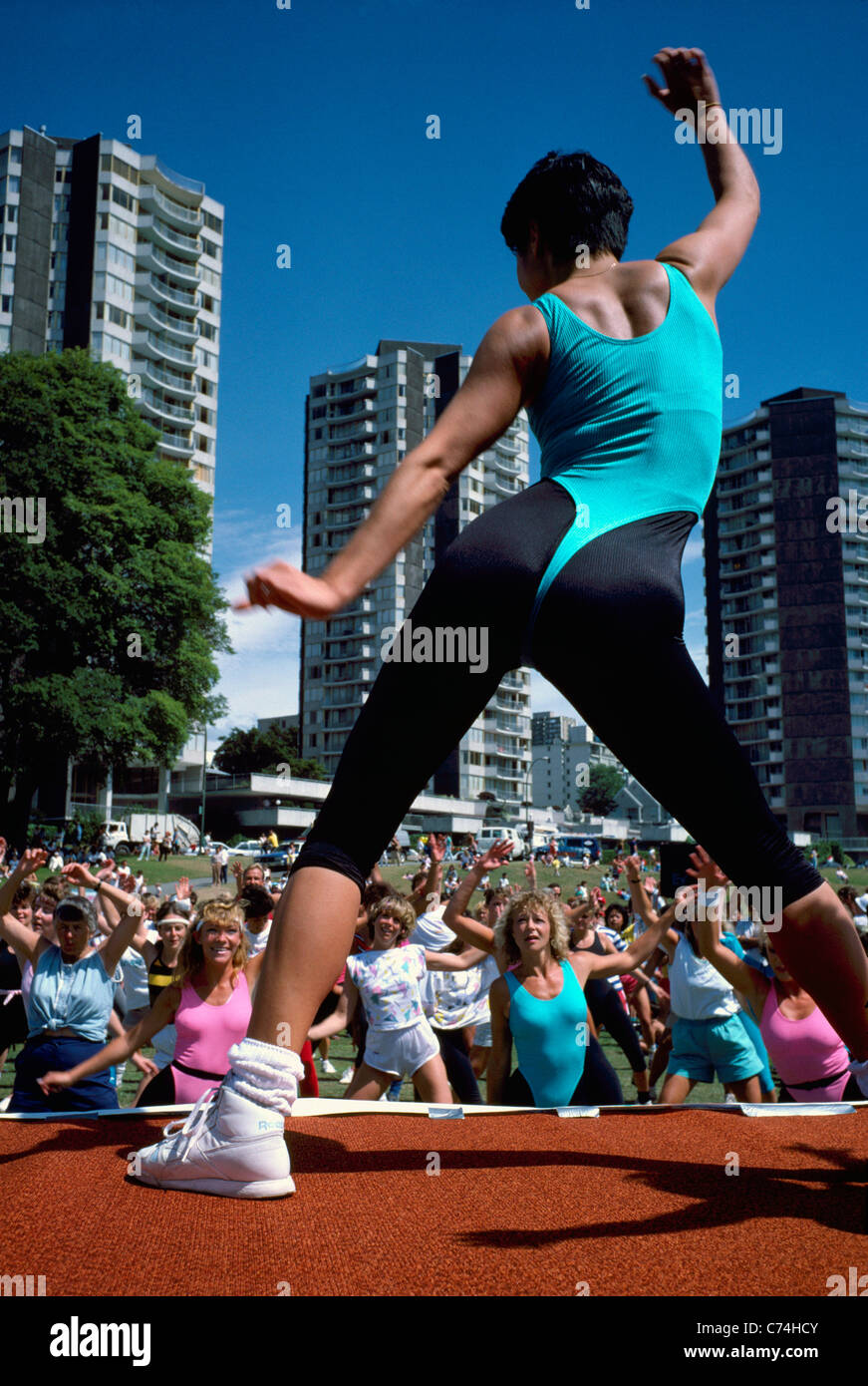 Donna esercizio all'aperto e leader di un gruppo di adulti in esercizio Outdoor Classe, West End di Vancouver, British Columbia, Canada Foto Stock